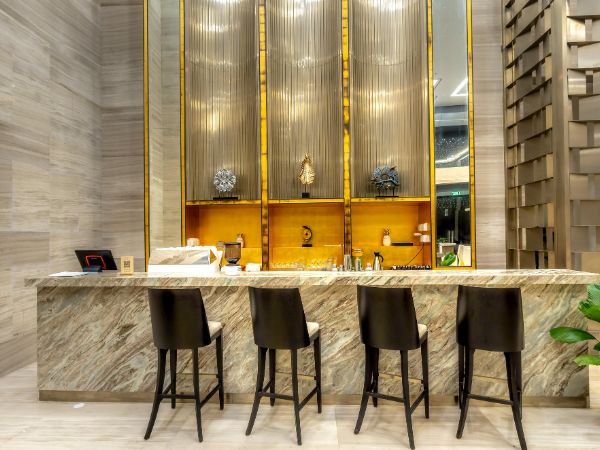 Luxurious marble bar counter with modern high chairs by a trusted Bar Counter Manufacturer in Delhi.